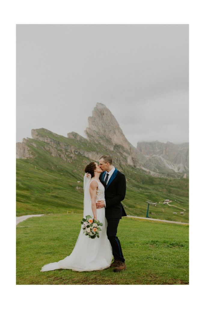 bride and groom kissing each other dolomites